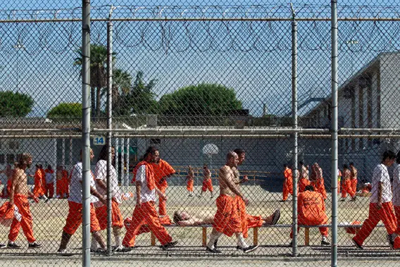 Inmates walk around an exercise yard at the California Institution for Men state prison in Chino
